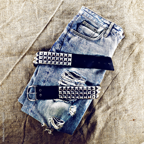 Vintage blue jeans with metal strap. Grunge fashion style photo