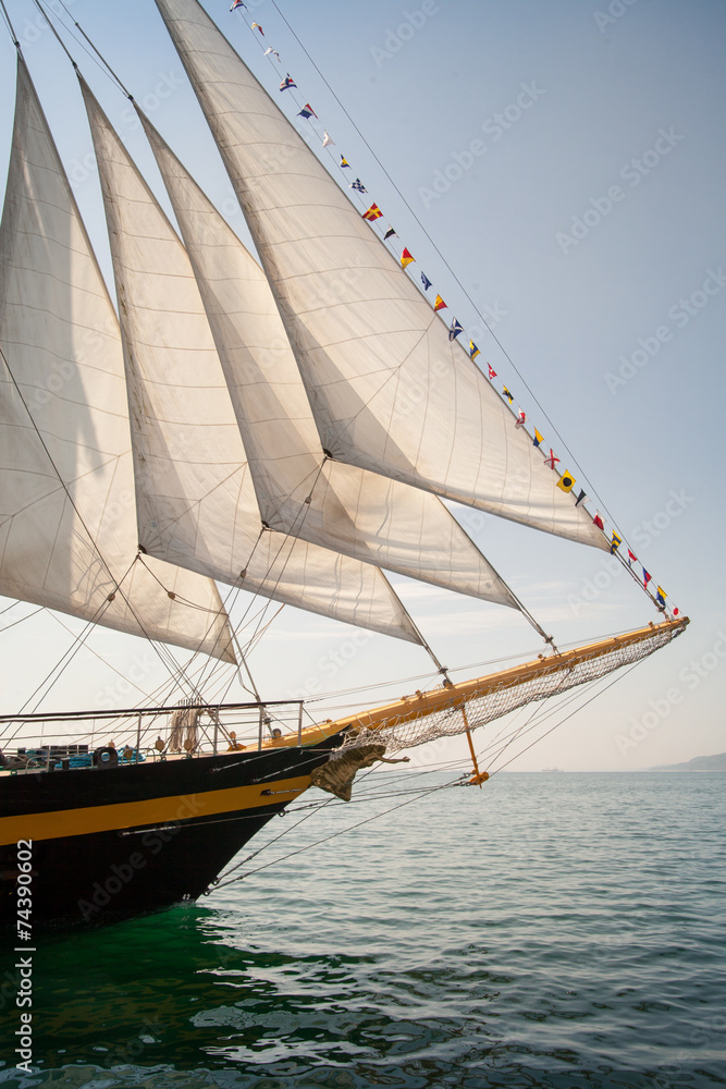 Naklejka premium Old ship with white sales, sailing in the sea