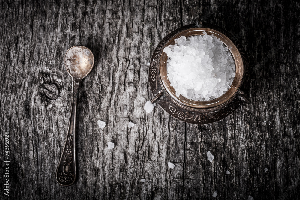 sea salt in an old utensils and a small spoon on a wooden table sea salt in an old utensils and a small spoon on a wooden table