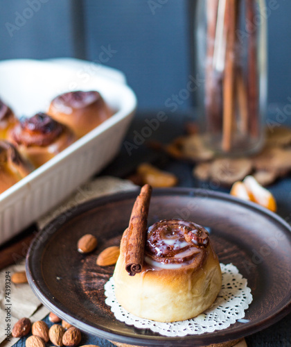 Cinnabon cinnamon rolls, almonds and mandarins on a dark plate