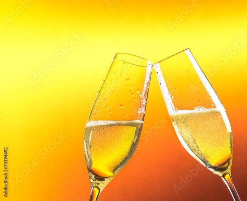 two flutes of champagne with golden bubbles and space for text