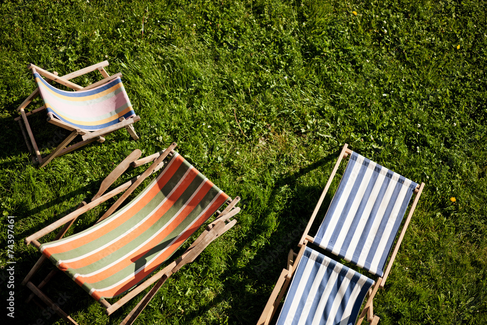 Samolepka Empty deckchairs on a green lawn