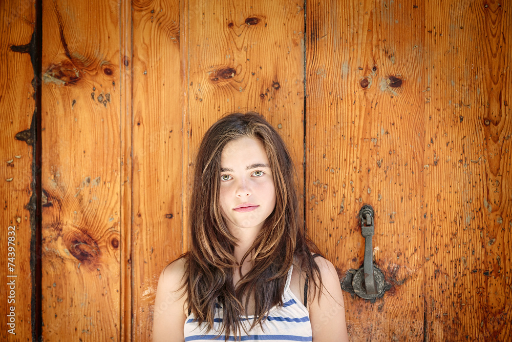Fototapeta premium portrait of a beautiful teenage girl in front of an ancient wood