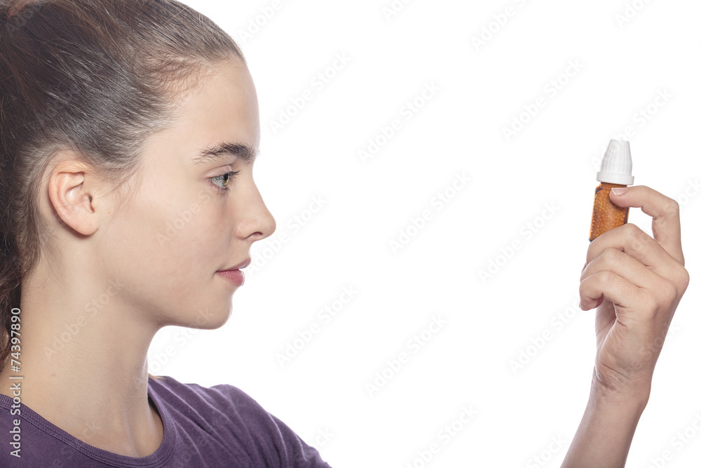 woman is examine a bottle of homeopathic medicine, isolated on w woman is examine a bottle of homeopathic medicine, isolated on w