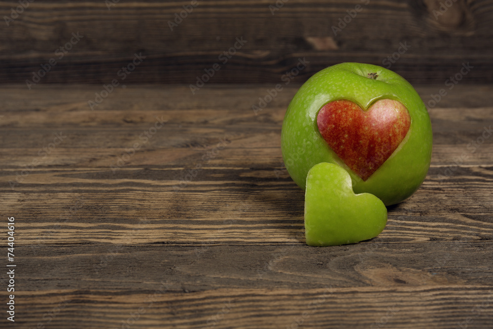 Apple in the shape of a heart on wooden planks Apple in the shape of a heart on wooden planks