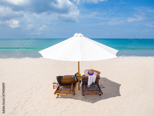 Lady in white hat sitting in chaise longue