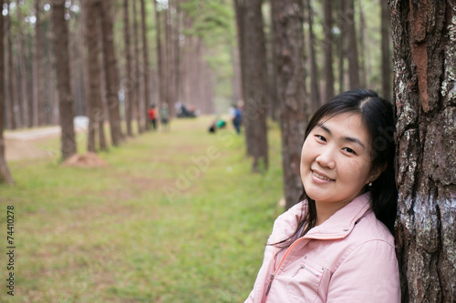 Girl with a smail in pine plantation © sakdinon