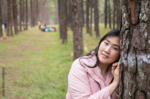 Girl with a smail in pine plantation