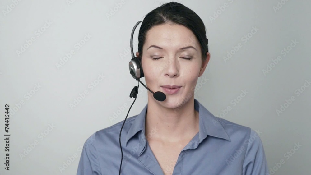 Mitarbeiterin in einem Callcenter spricht mit Headset Mitarbeiterin in einem Callcenter spricht mit Headset