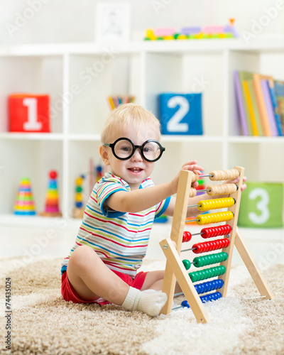 child with eyeglasses playi...