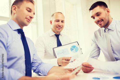 smiling businessmen with papers in office