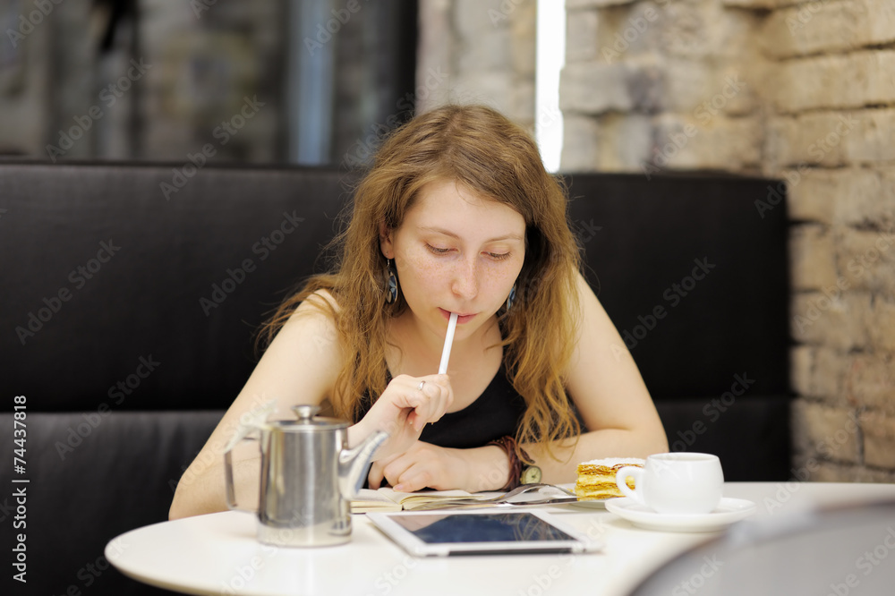 Young woman working on her tablet computer Young woman working on her tablet computer