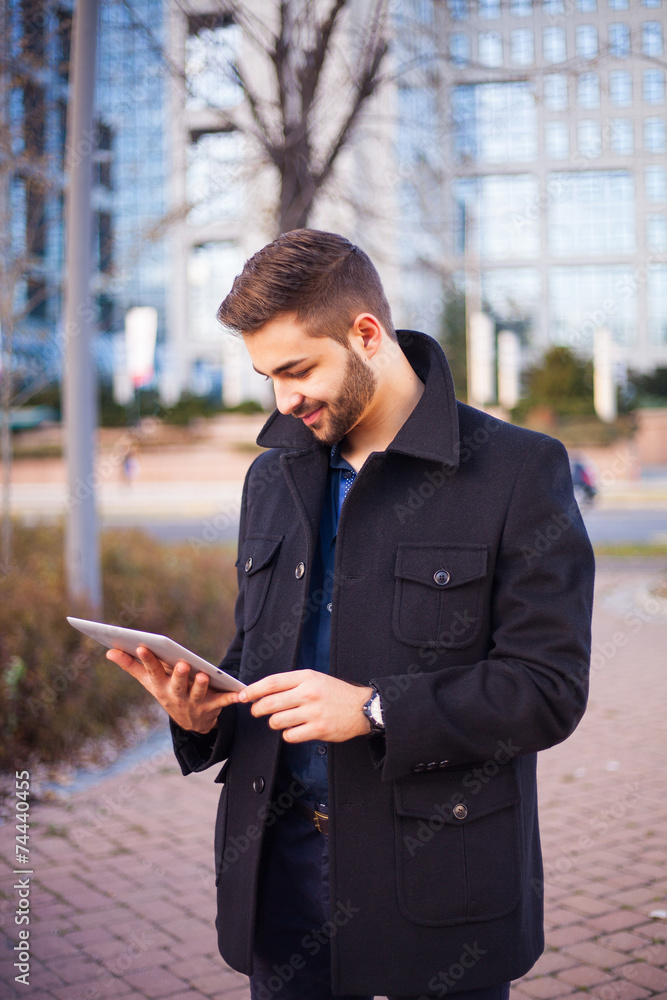 A smart young businessman with a beard using a tablet computer A smart young businessman with a beard using a tablet computer