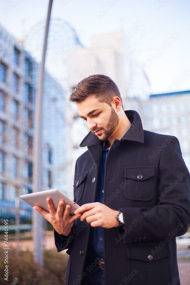 A smart young businessman with a beard using a tablet computer A smart young businessman with a beard using a tablet computer