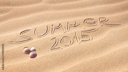 Summer 2015 handwriting with shells on a wavy pattern of sand