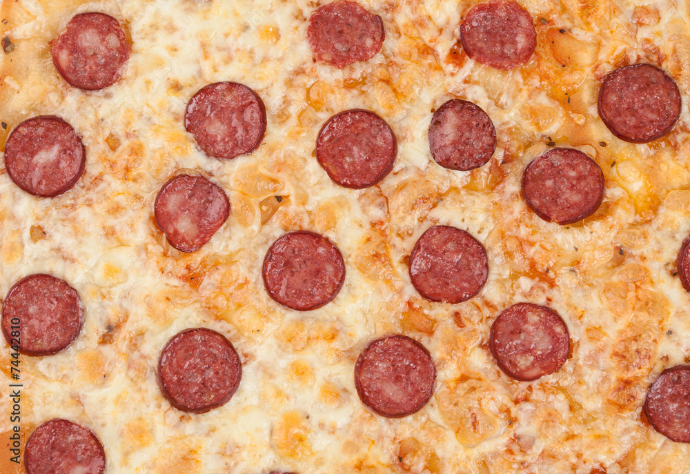 Thinly sliced pepperoni is a popular pizza as background Thinly sliced pepperoni is a popular pizza as background