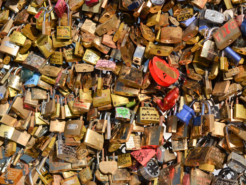 Lots of colorful locks on a bridge in Paris, France. © kobolia