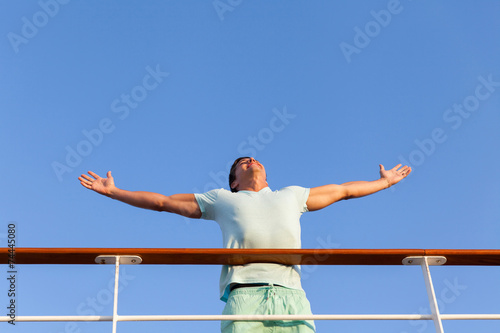 Foto young man with arms outstretched on cruise ship