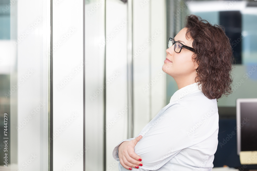 Young woman at the office looking at the window Young woman at the office looking at the window