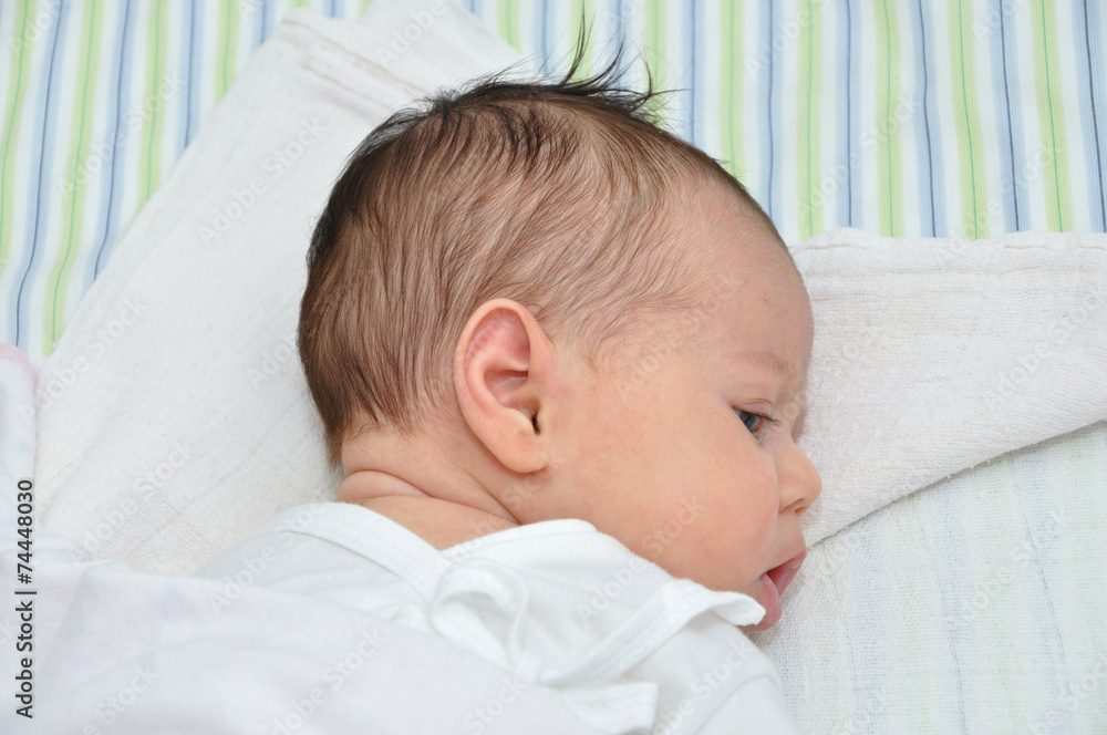 Cute newborn baby girl lying in bed Cute newborn baby girl lying in bed