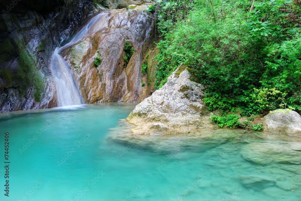 Naklejka premium Natural pool with azure water and a small waterfall