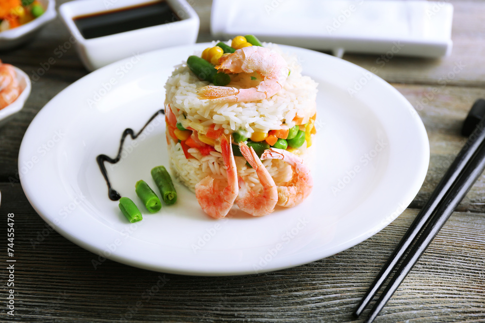 Boiled rice with shrimps and vegetables on wooden background Boiled rice with shrimps and vegetables on wooden background