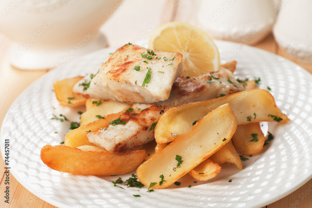 Cod fish steak with fried potato and lemon