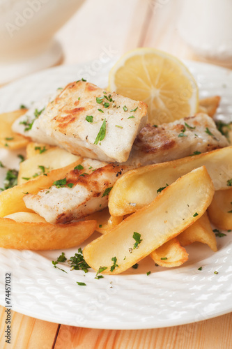 Cod fish steak with fried potato and lemon