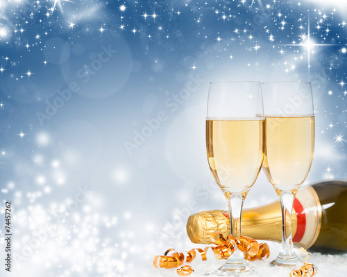 Glasses with champagne and bottle over holiday background