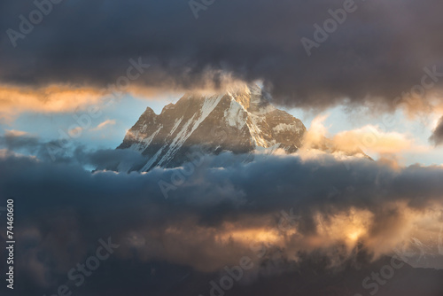 Snow mountain partly obcured by clouds photo