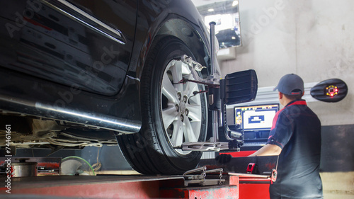 Car on stand with sensors on wheels for wheels alignment camber photo