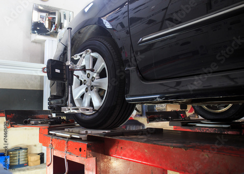 Photos Car on stand with sensors on wheels for wheels alignment camber
