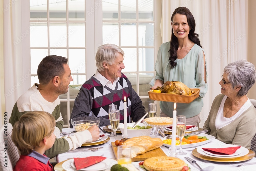 Woman holding turkey roast with family