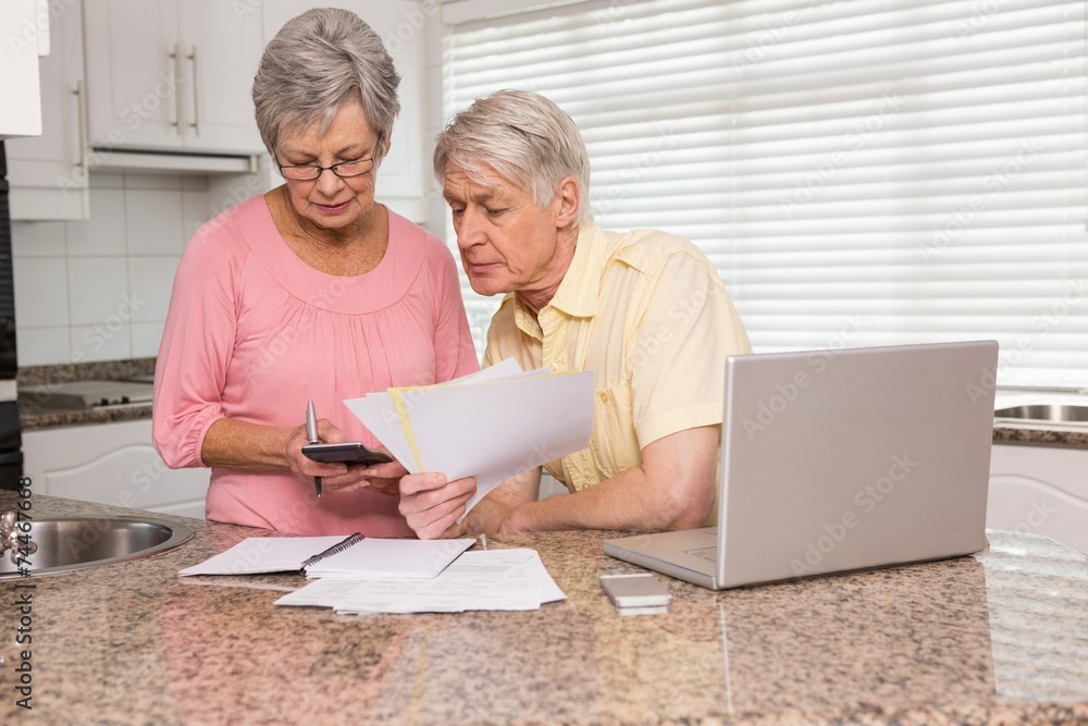 Senior couple paying their bills with laptop Senior couple paying their bills with laptop