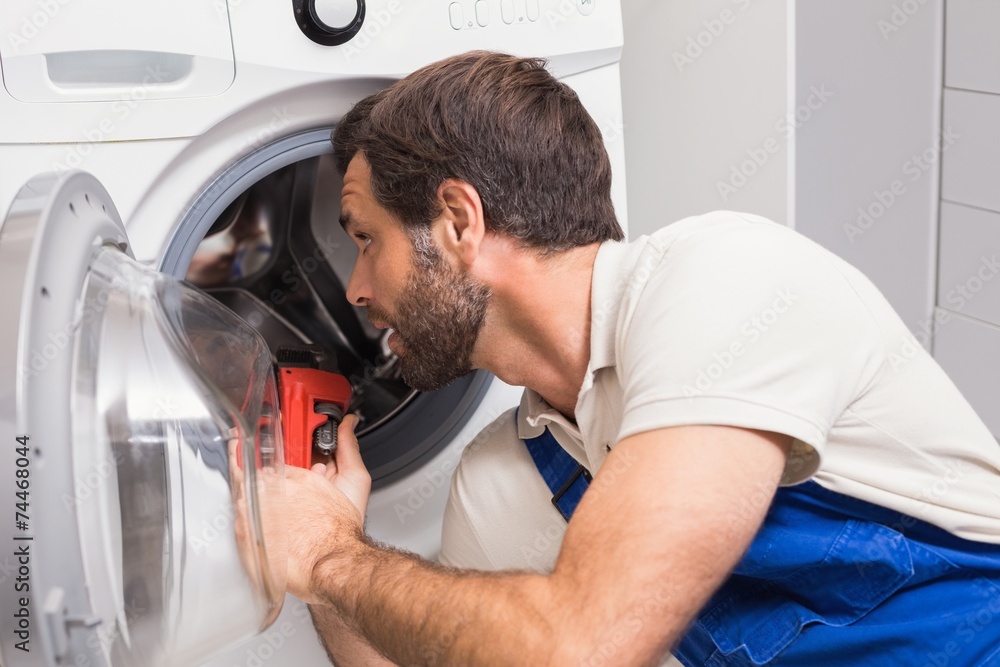© WavebreakMediaMicro - Handyman fixing a washing machine