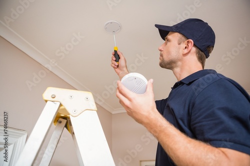 Handyman installing smoke detector photo