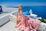 Beautiful blond woman with long legs in a pink ball gown