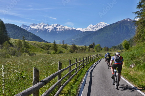 Italian Alps-unknown cyclists on the bicycle path to Laudes