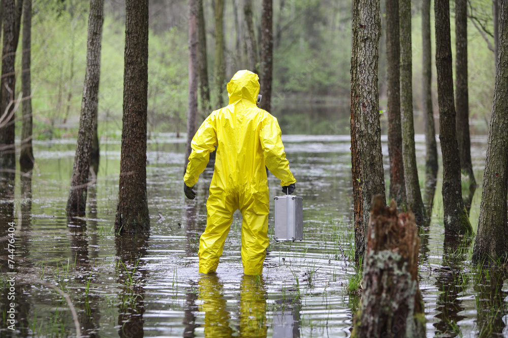 man in uniform with suitcase in contaminated floods area man in uniform with suitcase in contaminated floods area
