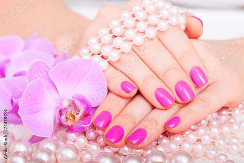Beautiful pink manicure pedicure. Well-groomed female hands spa