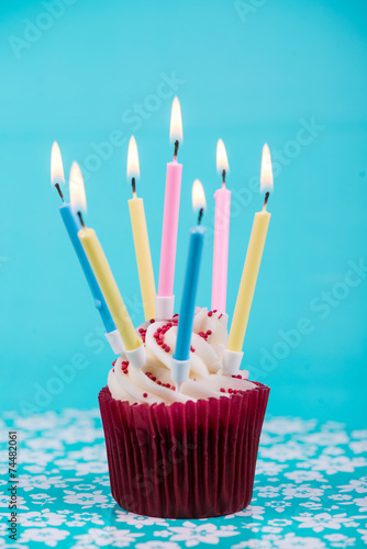  birthday cup cake with many candles on blue background