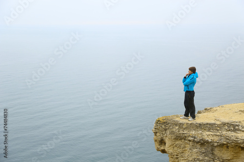beautiful woman on a cliff above the sea