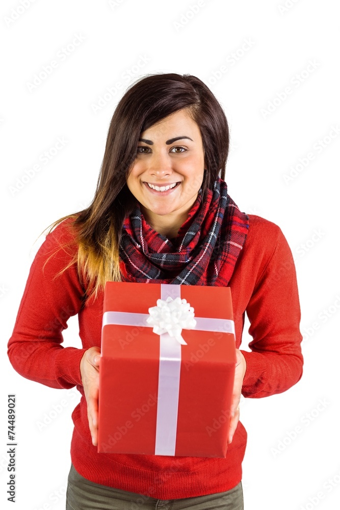 Smiling brunette showing a gift with white bow Smiling brunette showing a gift with white bow