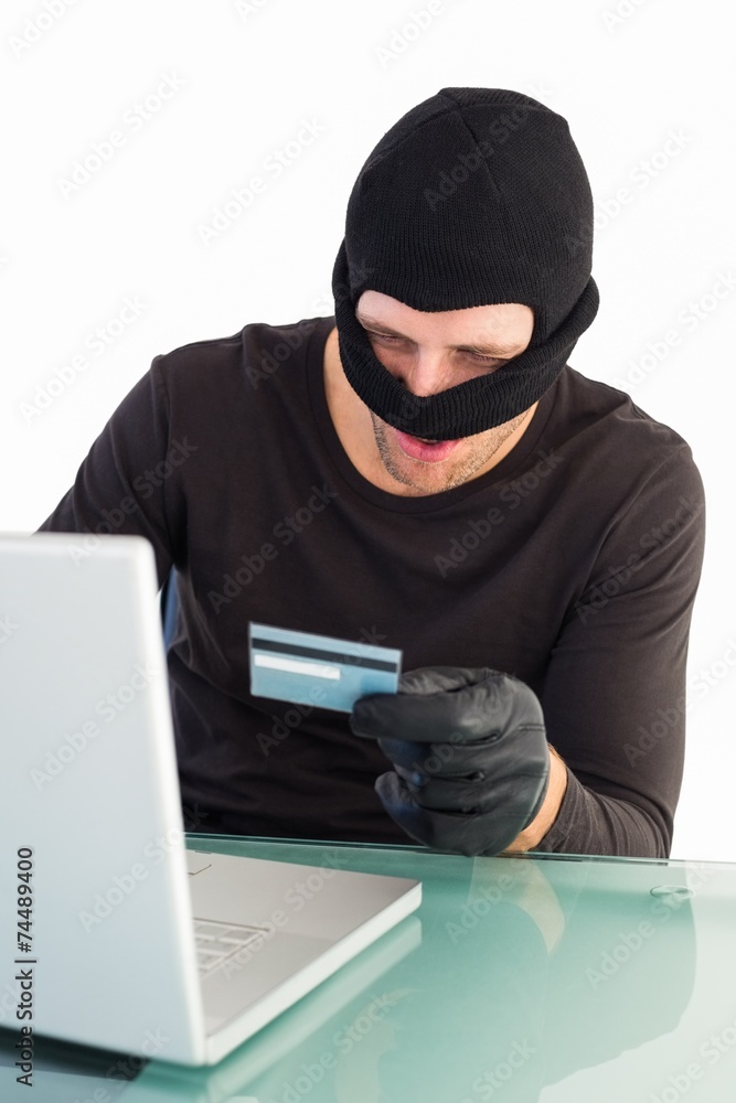 Burglar shopping online with laptop Burglar shopping online with laptop