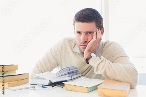 Bored casual businessman studying at his desk