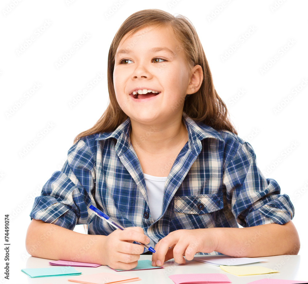 Girl is writing on color stickers using pen Girl is writing on color stickers using pen