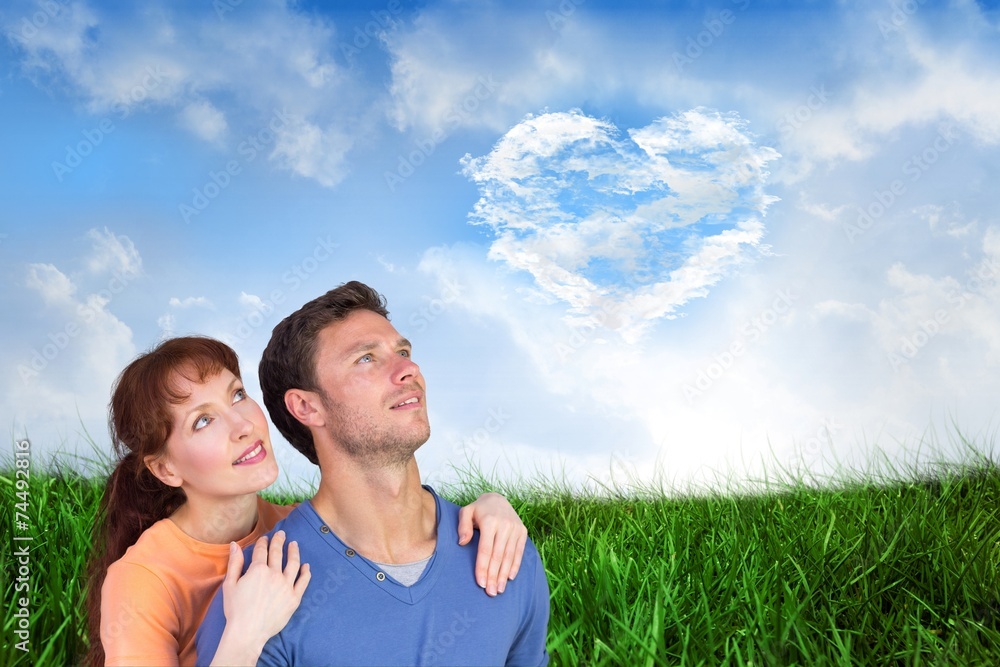 Composite image of happy couple looking upwards Composite image of happy couple looking upwards