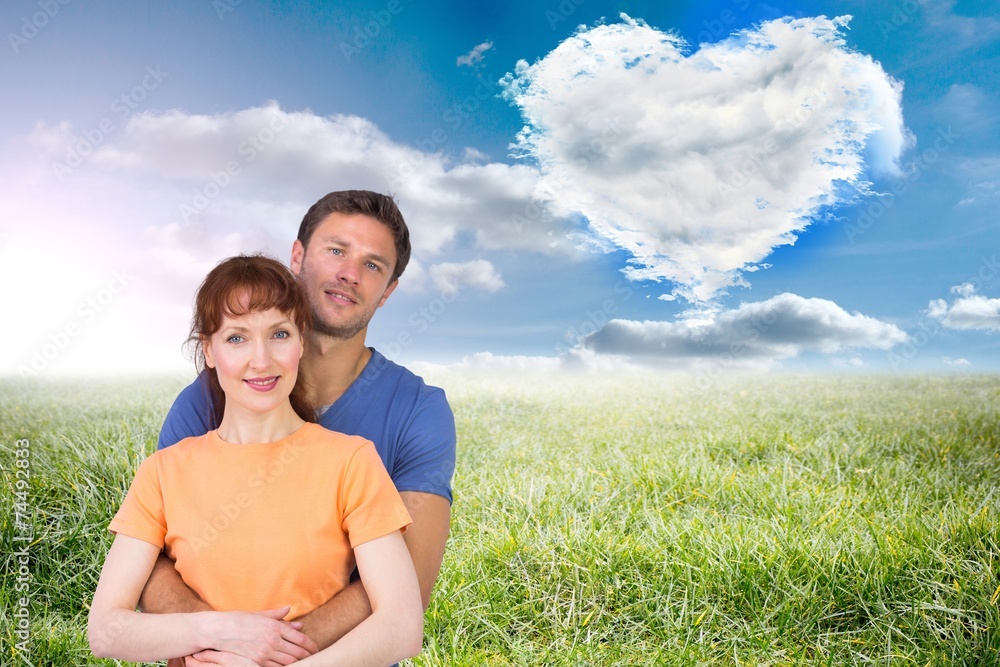 Composite image of happy couple looking at camera Composite image of happy couple looking at camera