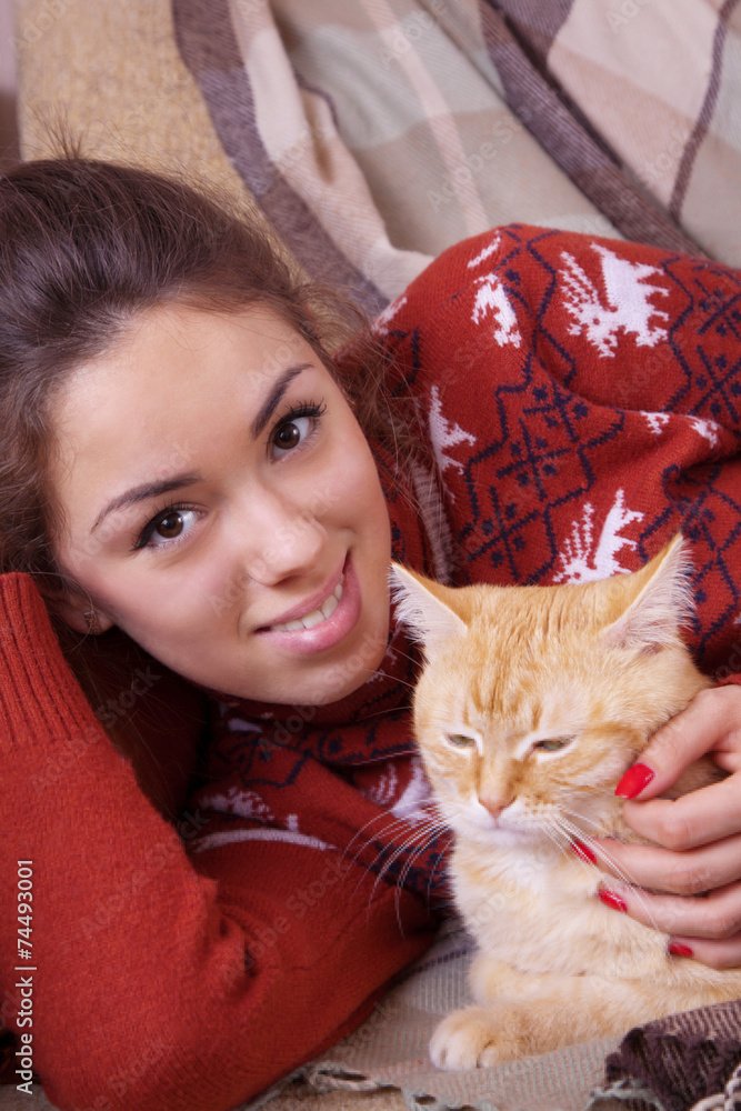 Young woman resting on sofa with a cat