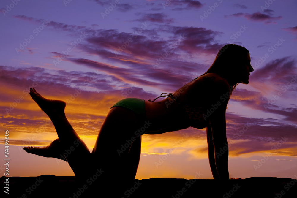 silhouette of woman in bikini on knees feet up
